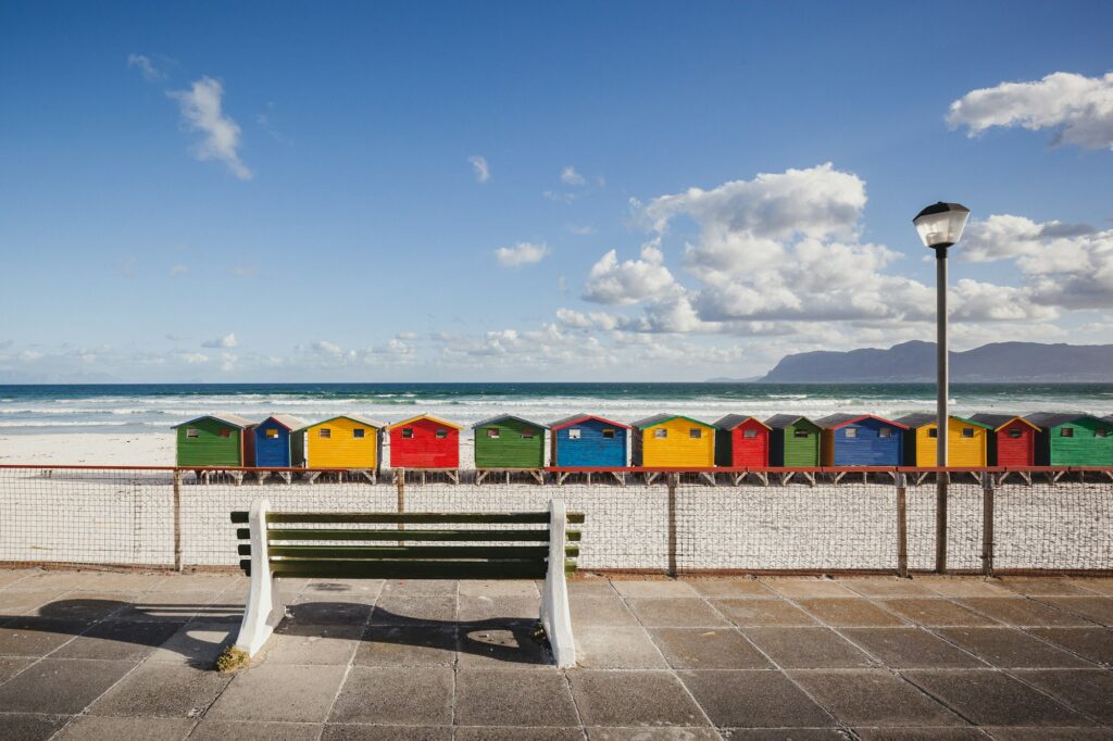Bench overlooking colorful beach cabins in Kalk Bay, South Africa
